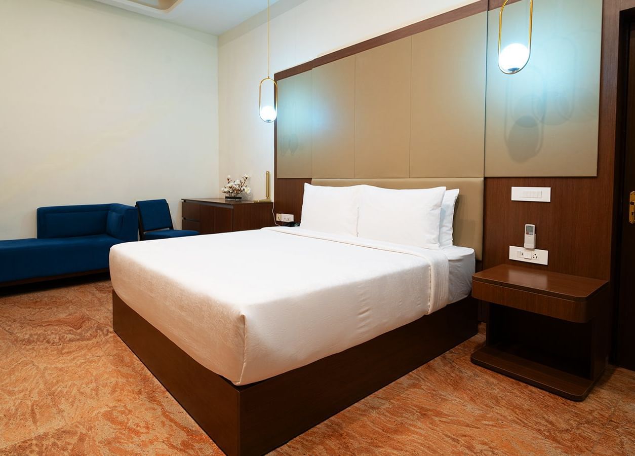 Deluxe Suite 1An image of a suite with a large bed, night stands, and lamps hanging from the ceilings - Accord Chrome Airport Hotel